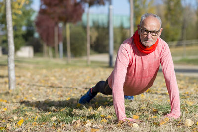 Senior man exercising on field at park