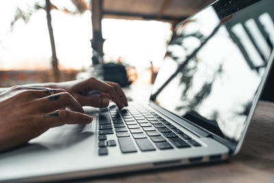 Midsection of man using laptop on table