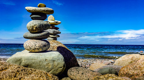 Stack of pebbles on beach against sky