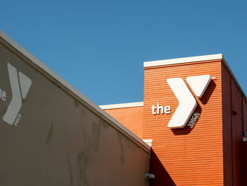 Low angle view of sign on building against clear sky