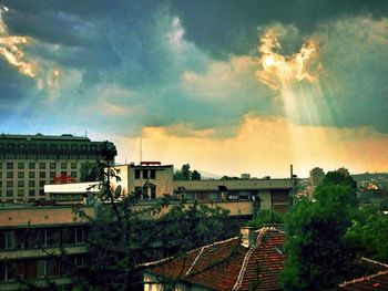 Buildings against cloudy sky at sunset