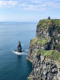 Scenic view of rocks on sea against sky