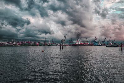 Panoramic view of harbor against dramatic sky