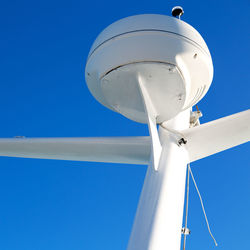 Low angle view of electric lamp against blue sky