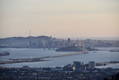 High angle view of buildings by river against sky