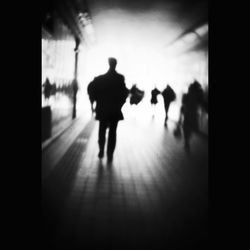 Silhouette people walking in corridor