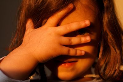 Close-up of cute girl covering face