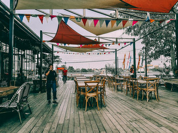 Rear view of man and tables at cafe