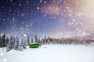 Snow covered land against sky at night