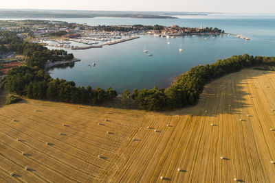 High angle view of sea by city against sky