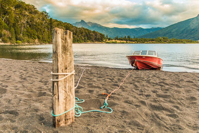 Deck chairs on beach against sky