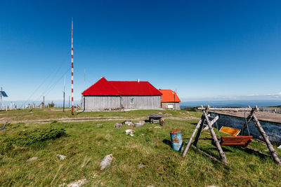 House on field against clear blue sky