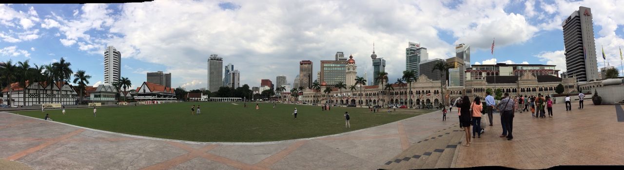 building exterior, architecture, built structure, city, sky, large group of people, cloud - sky, modern, men, skyscraper, city life, person, grass, office building, capital cities, cloud, tower, famous place, leisure activity