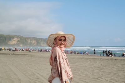 Full length of woman standing at beach against sky