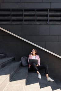 Rear view of woman sitting on staircase