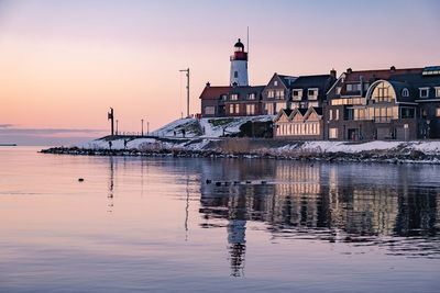 Reflection of buildings in lake at sunset