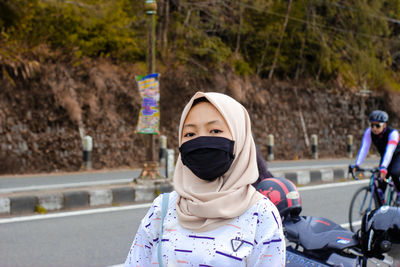 Rear view of woman standing on road