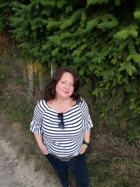 Portrait of smiling young woman standing on land