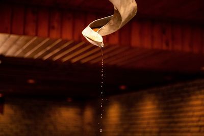 Close-up of water drop hanging on wood