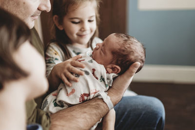 Close up side view of newborn boy and family in hospital with family