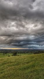 Scenic view of field against cloudy sky