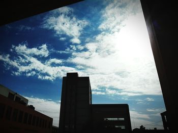 Low angle view of buildings against cloudy sky