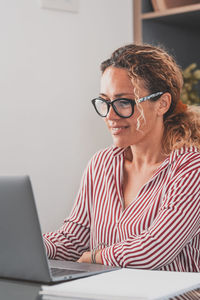 Smiling businesswoman using laptop at office