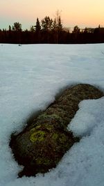 Scenic view of snow covered land during sunset