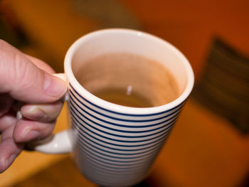 Close-up of hand holding a mug