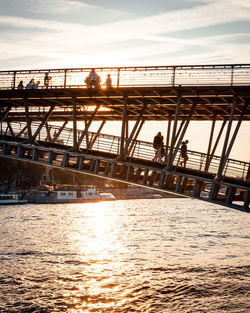 Bridge over river against sky during sunset