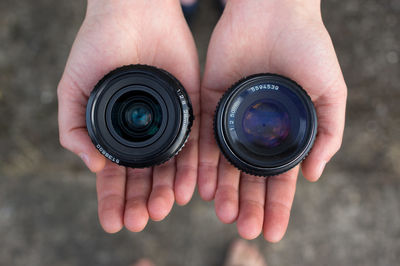 Cropped hands holding camera lens
