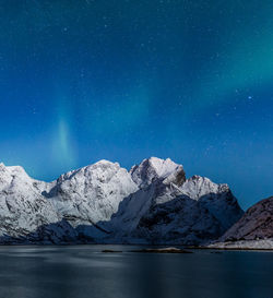 Scenic view of snowcapped mountains against sky at night