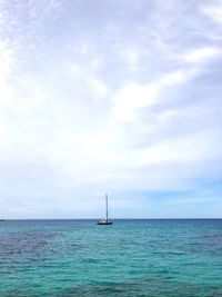 Sailboat sailing on sea against sky