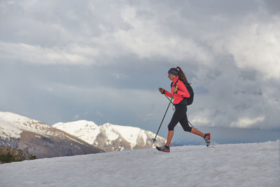 Athlete woman runs on the snow for skyrunning practice