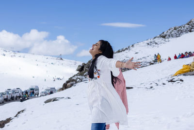 An indian beautiful woman enjoying cold in snowy mountain