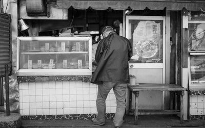 Rear view of man working at store