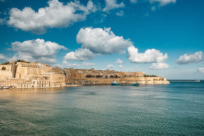 View of the harbor entrance of valletta, blue sky with a few clouds and the mediterranean sea