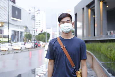 Portrait of young man standing in city