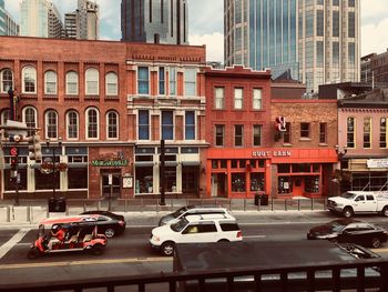 Traffic on road by buildings in city