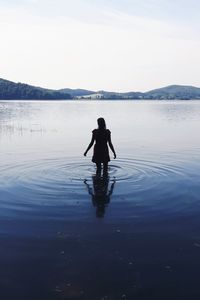 Rear view of woman standing on water