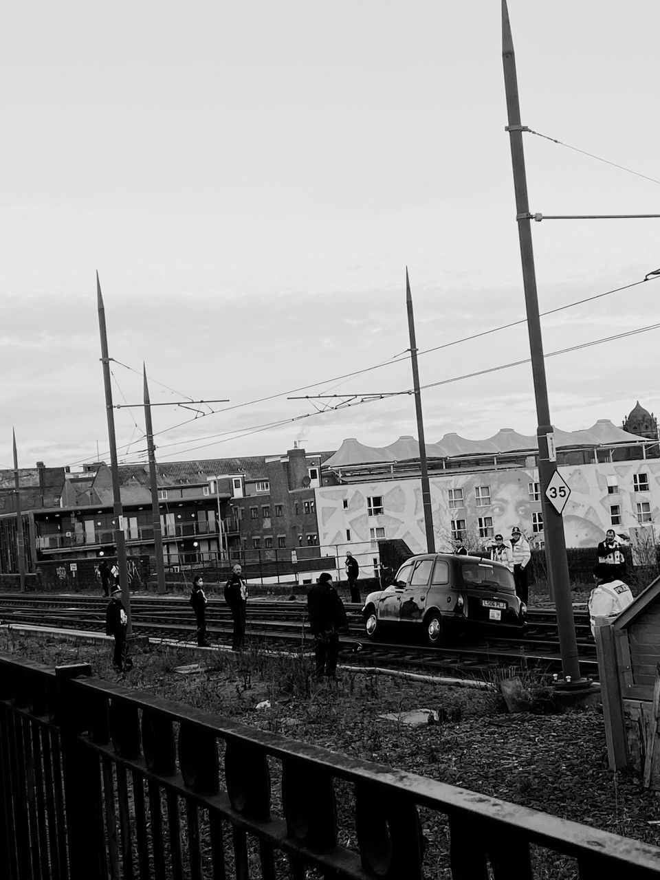 RAILROAD TRACKS AMIDST BUILDINGS AGAINST SKY