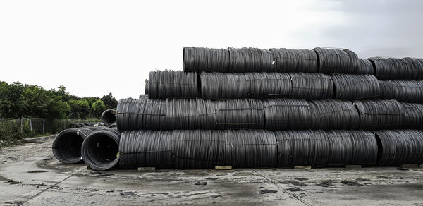 Stack of pipes against sky