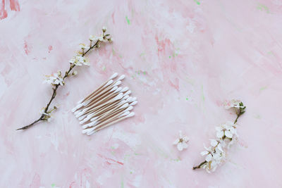 Eco-friendly bamboo cotton buds on pink, white spring flowers. cotton swabs, ear cleaner