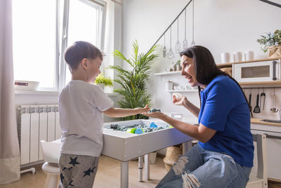 Side view of woman using laptop at home