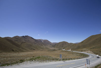 Road by mountain against clear sky