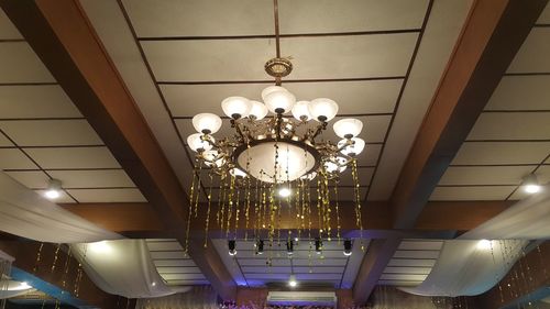 Low angle view of illuminated pendant lights hanging from ceiling