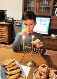 High angle view of boy arranging candles on holder