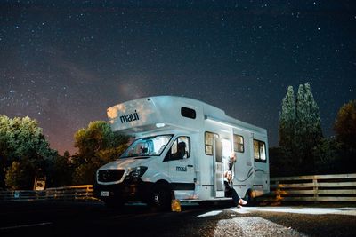 Cars on road against sky at night