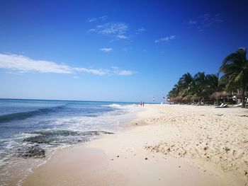 Scenic view of beach against blue sky