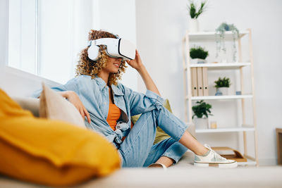 Young woman using mobile phone while sitting at home